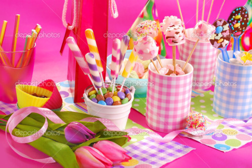 colorful birthday party table with flowers,gift and homemade sweets for kids